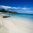 Small skiff beached on empty white sand tropical beach. Roatan, Honduras